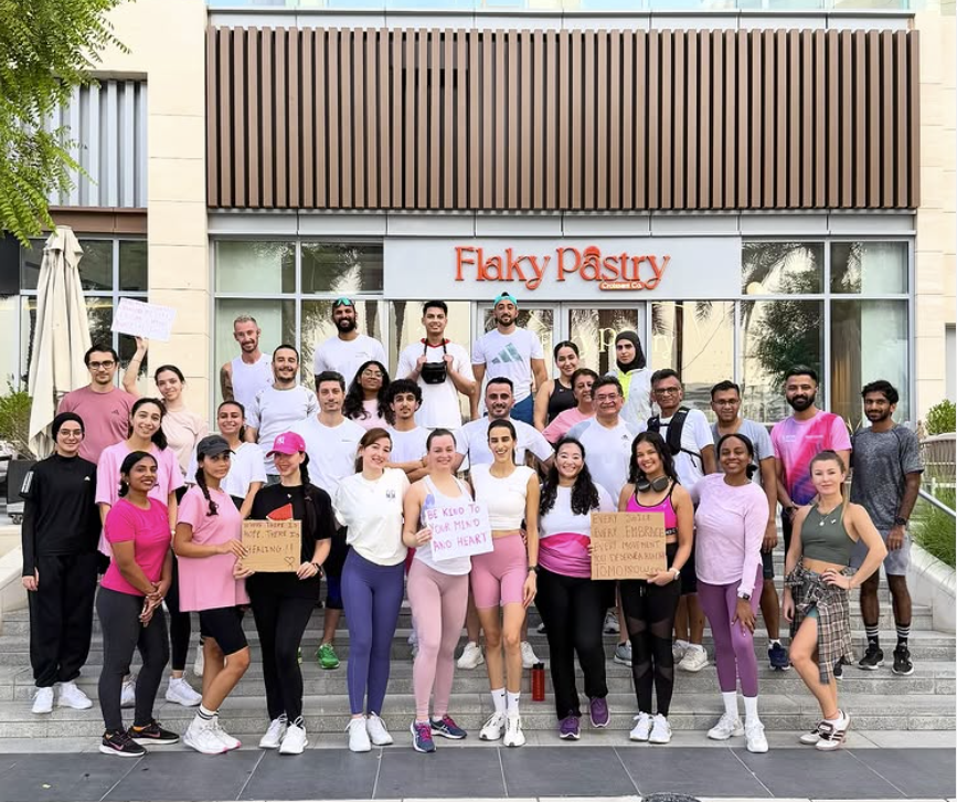Croissant Run Club members posing together in front of Flaky Pastry in Dubai